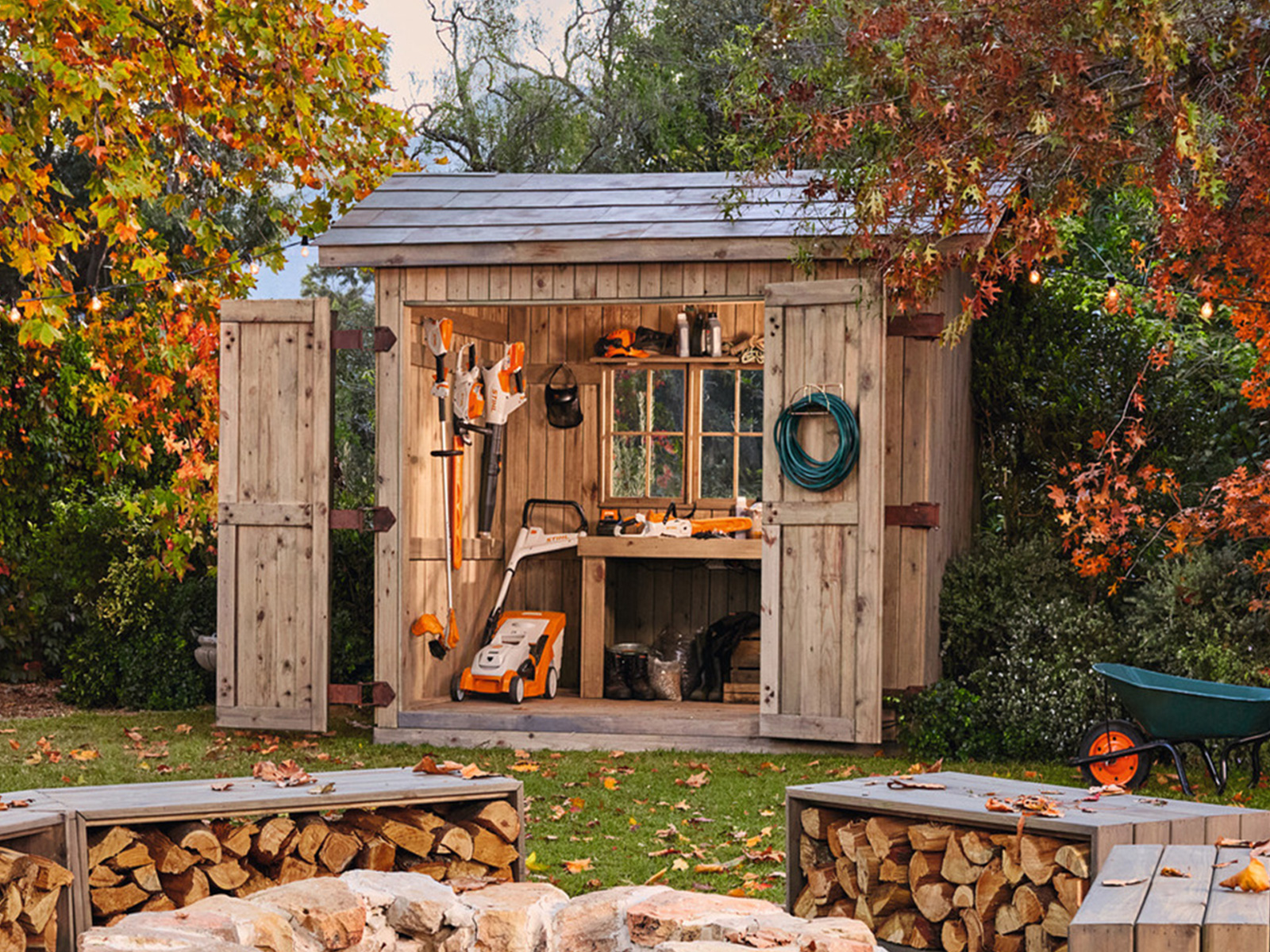 Jardin d’automne avec hangar rempli d’outils de jardinage STIHL et feu de camp agréable