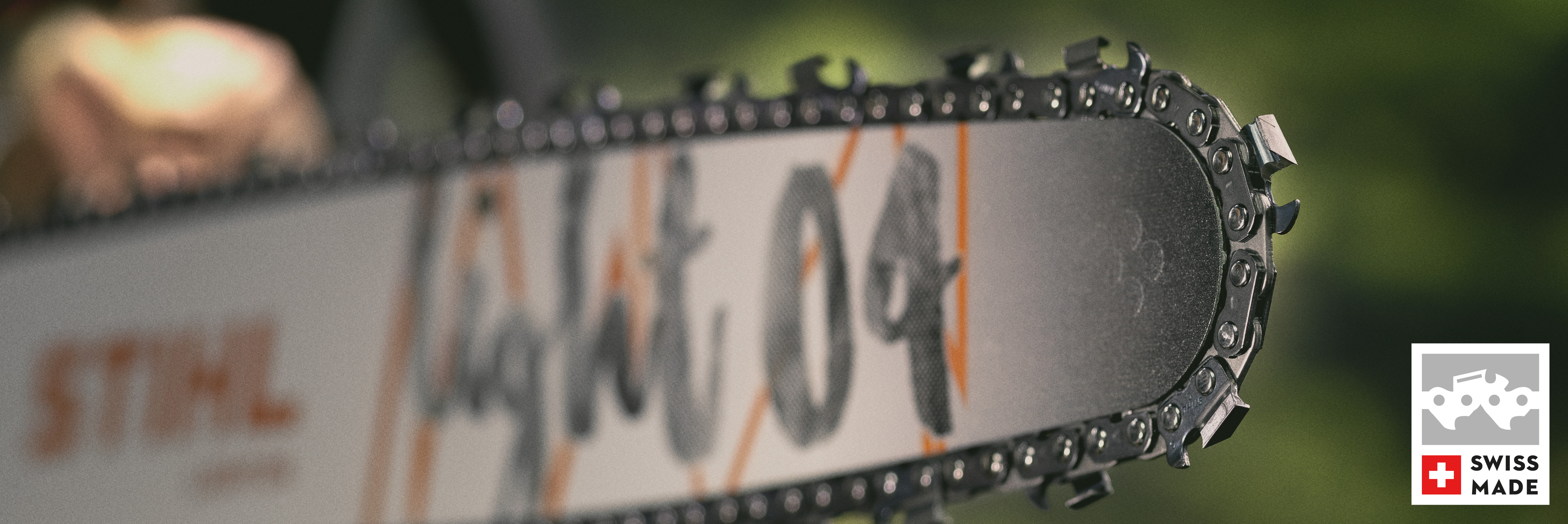 Gros plan du guide-chaîne Light 04 et de la chaîne Super 36 RS avec logo de fabrication suisse