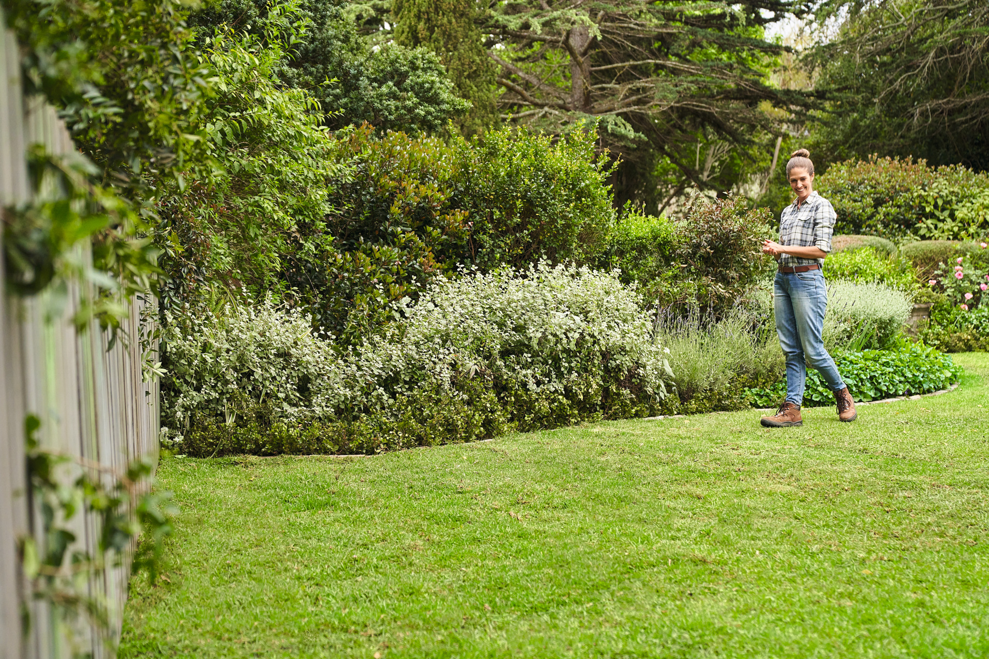 Une femme marche sur le gazon qui vient d’être installé dans son grand jardin 