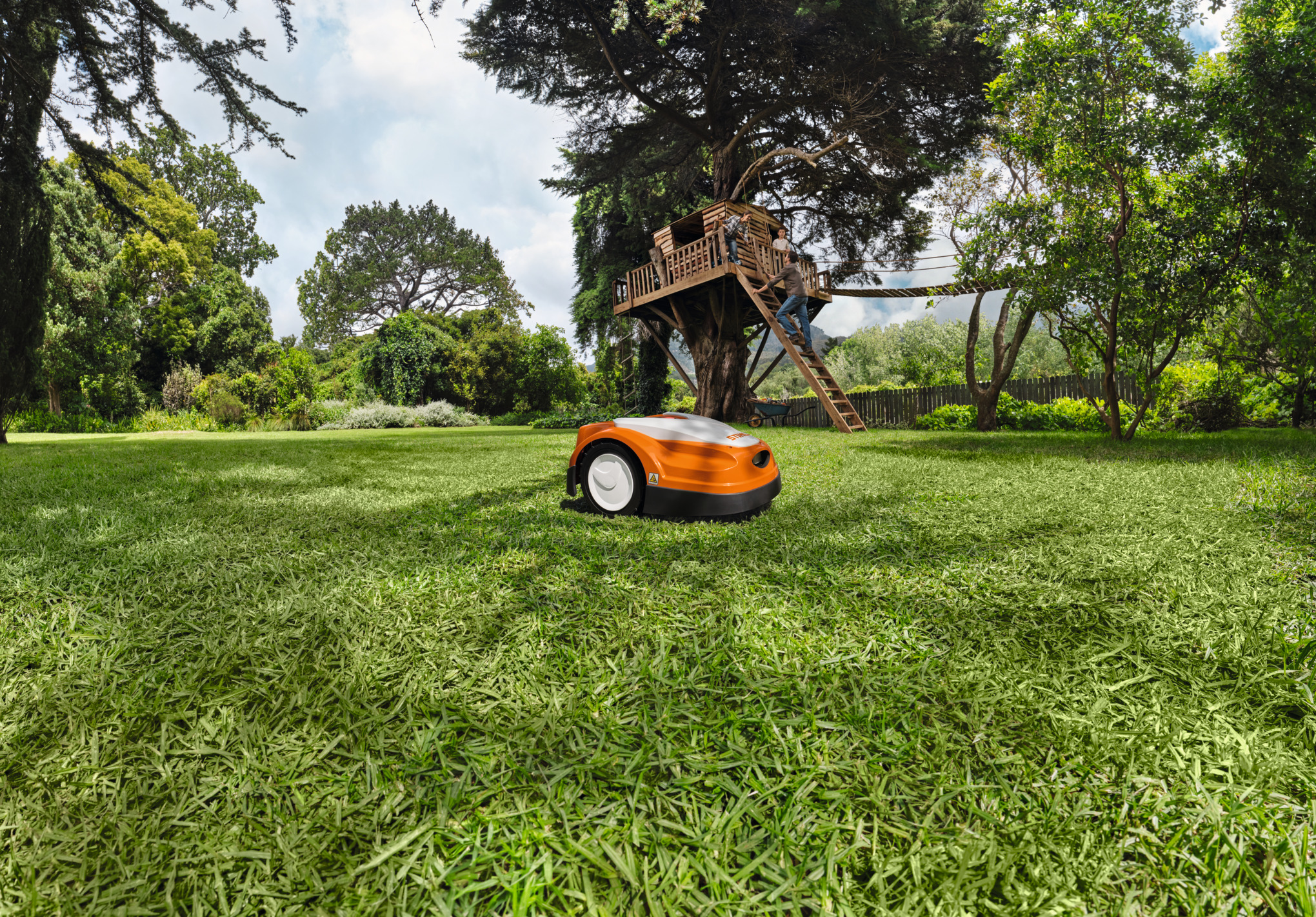Robot tondeuse RMI 422 STIHL surn une pelouse verte devant une cabane
