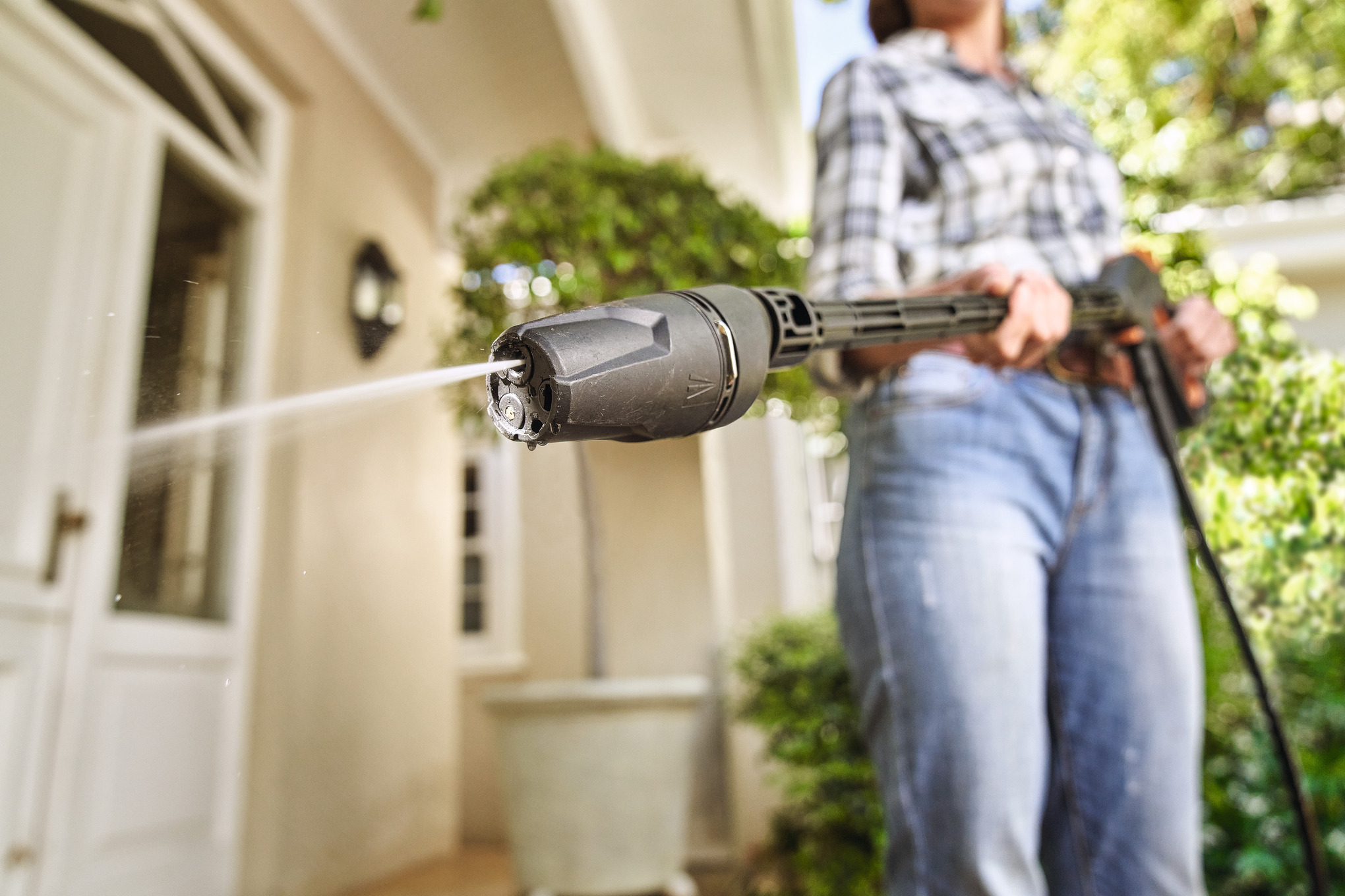 une femme nettoie son perron avec un nettoyeur haute pression STIHL