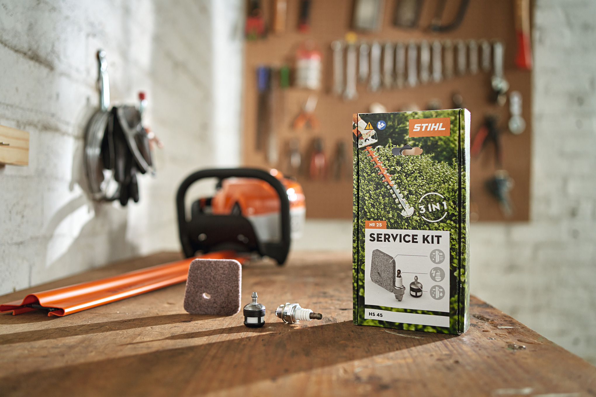 Taille-haie et son service kit posé sur une table d'atelier d'un garage