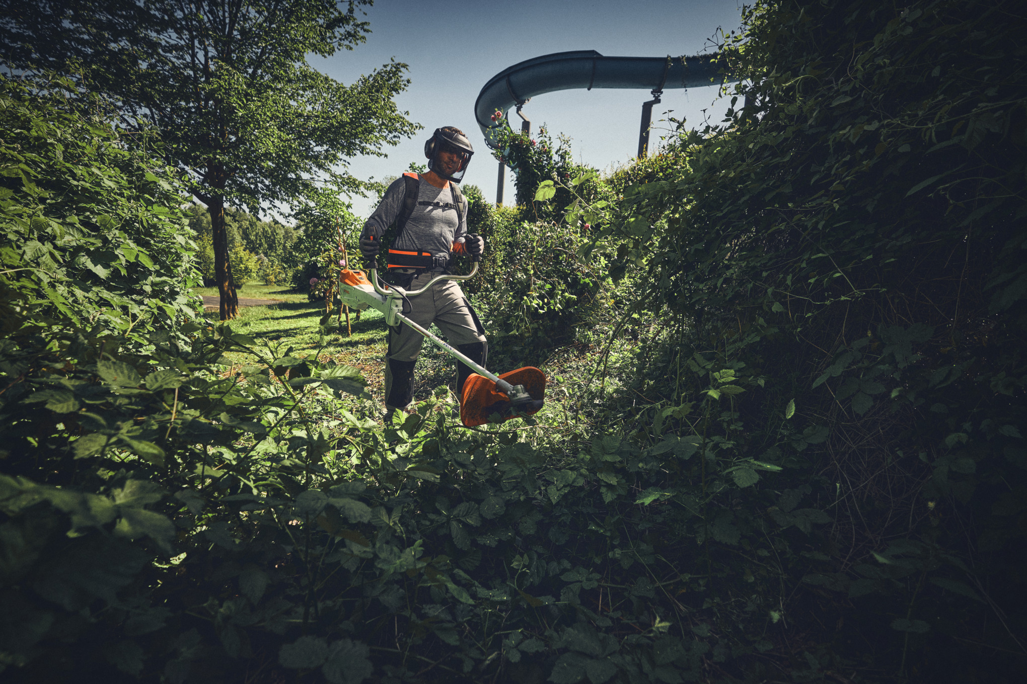 Homme avec débroussailleuse à batterie STIHL FSA 400 et débroussailleuse coupant des buissons – Battery Pro – Printemps 2025