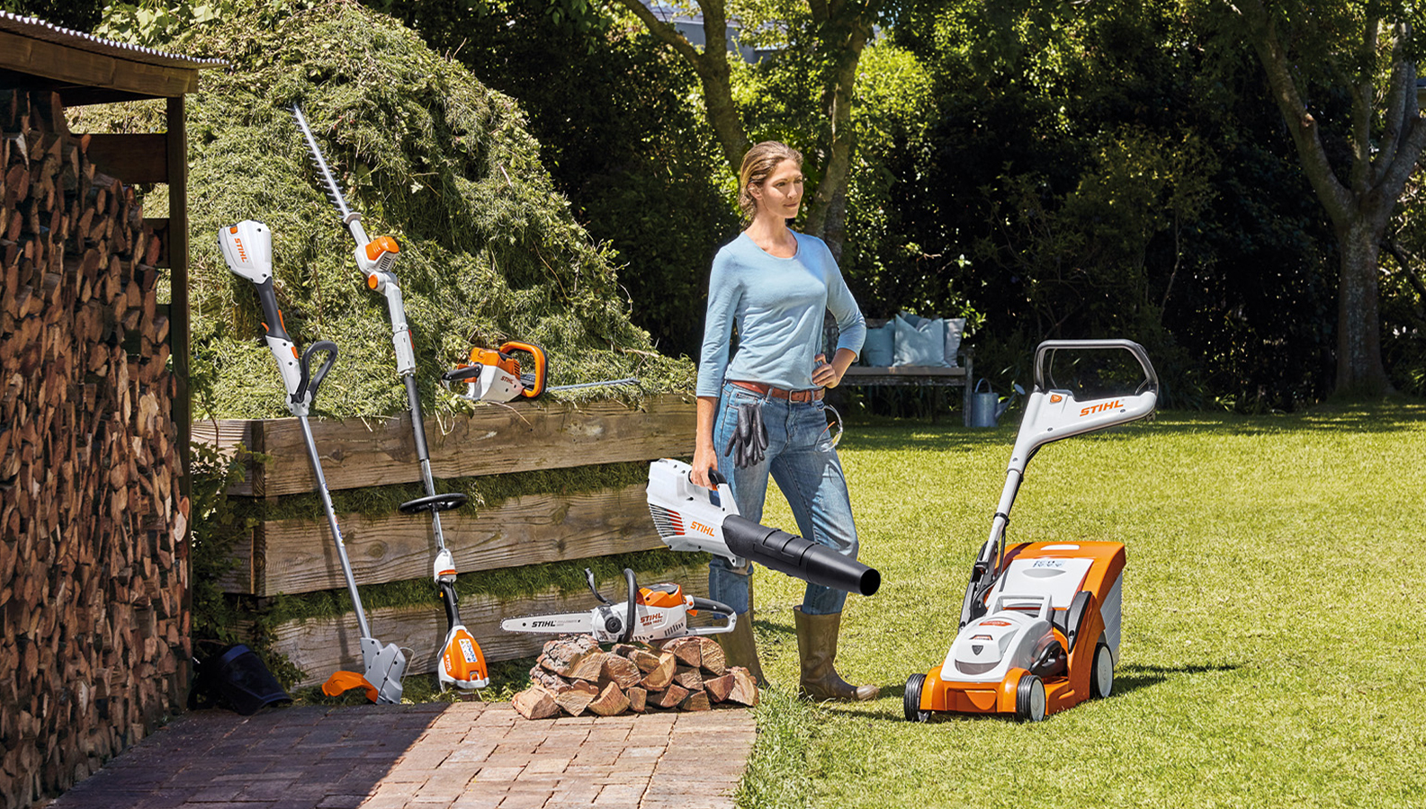 Une femme entourée d’une sélection de produits à batterie dans son jardin