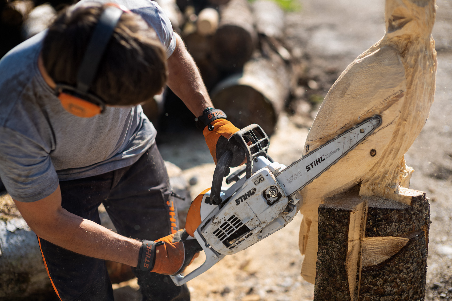 Un homme sculpte un hibou avec une tronçonneuse STIHL