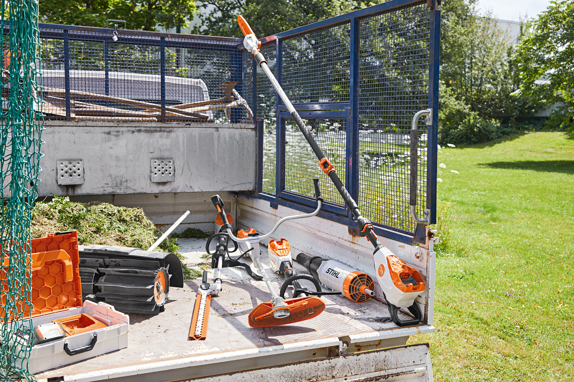 Véhicule équipé d'une perche d'élagage STIHL HTA 135, d'un taille-haie HLA 135, d'une débroussailleuse FSA 135 et d'un KMA 135 sur la zone de chargement