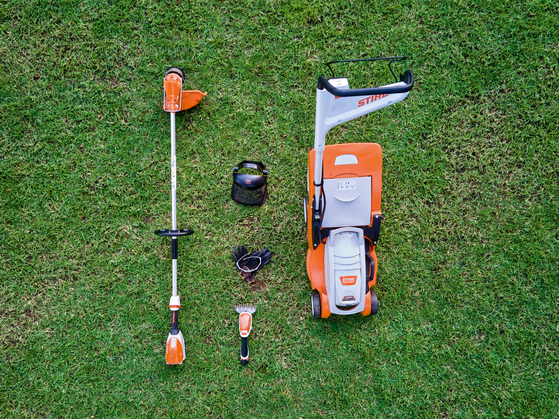 Tondeuse à gazon, débroussailleuse et taille-buissons à batterie STIHL HSA 26 sur une pelouse