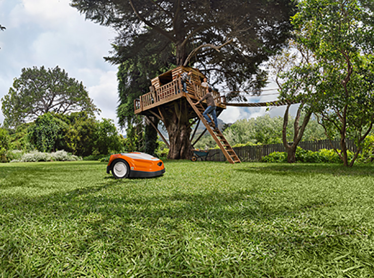 Couverture du catalogue produits STIHL 2021 qui met en avant le robot tondeuse iMOW dans un jardin avec une cabane dans un arbre en arrière plan