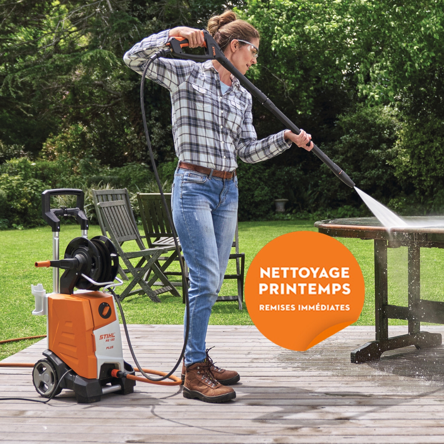 Une femme nettoie une table de jardin avec un nettoyeur haute pression STIHL