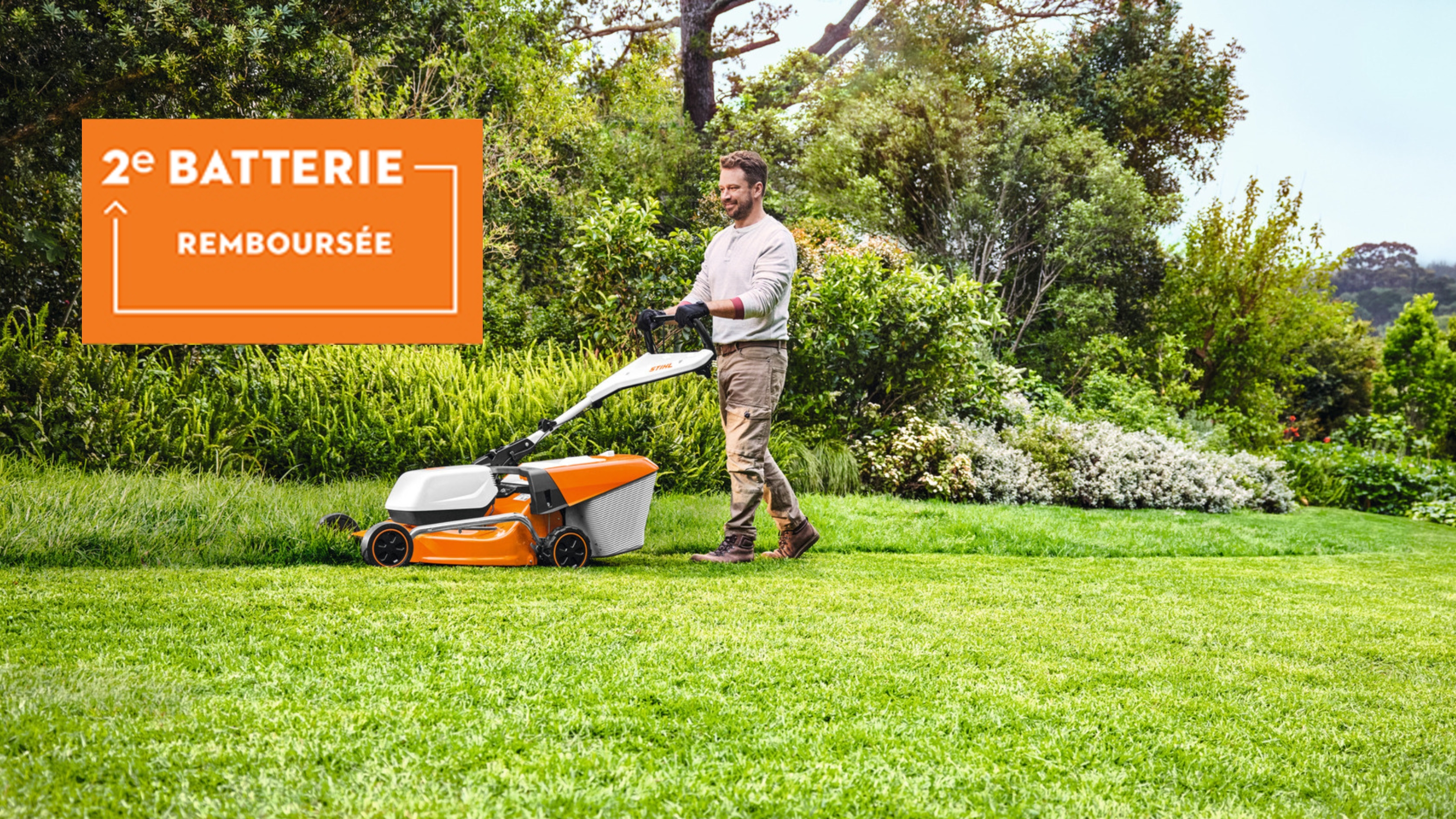 un homme tond sa pelouse avec une tondeuse à batterie AK SYSTEM et dans un rectangle orange deuxième batterie remboursée