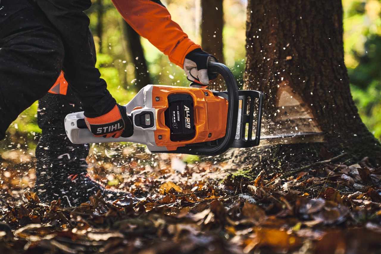 Un professionnel de l'exploitation forestière abat des arbres en forêt à l'aide d'une tronçonneuse sans fil de type STIHL MSA260 et d'une batterie ALLPRO