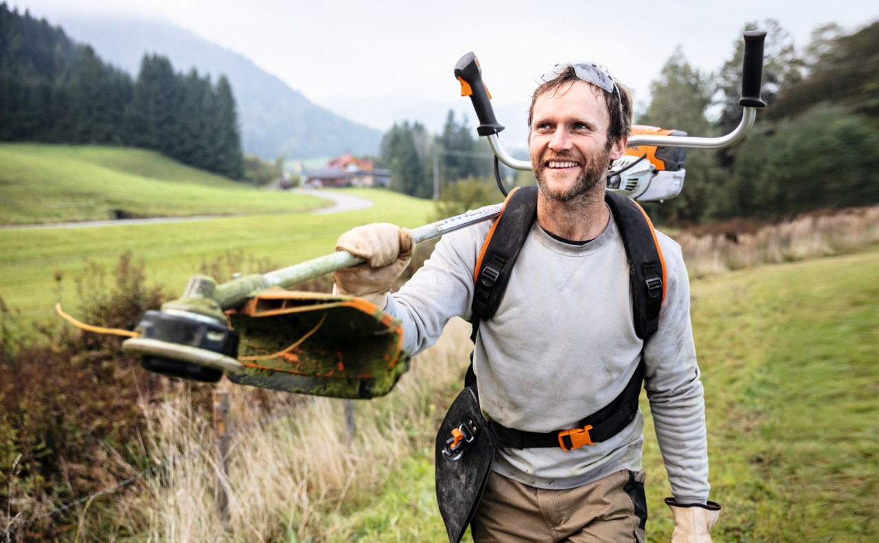 Homme souriant dans un champ avec la débroussailleuse STIHL FS 91