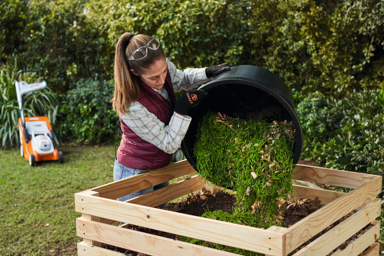 Femme versant du compost dans un bac à compost