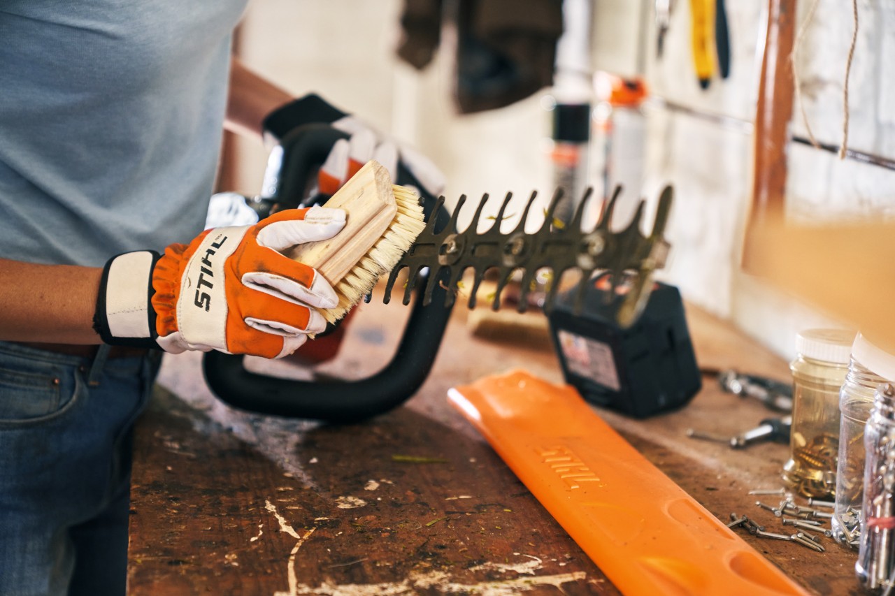 Le taille-haie STIHL HSA 56 fonctionnant sur batterie se nettoie avec une brosse